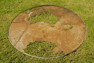 Lloyd Godman discarded corrugated iron water storage tank lid - grass